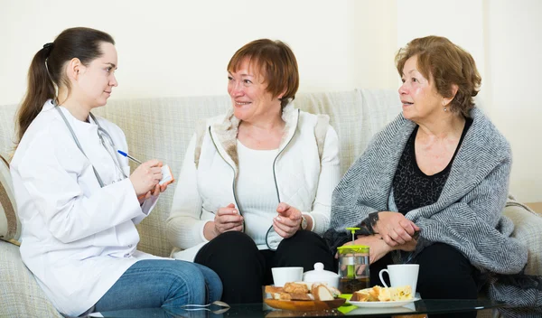 Pensioners discussing health problems with doctor — Stock Photo, Image