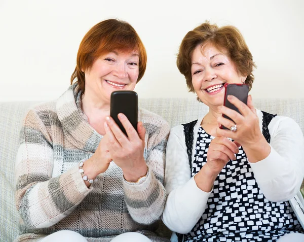 Mujeres mayores con teléfonos móviles Imágenes de stock libres de derechos