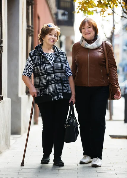 Pensionati femminili all'atto di passeggiata di città Foto Stock Royalty Free