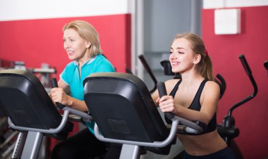 Women training on exercise bikes  clipart