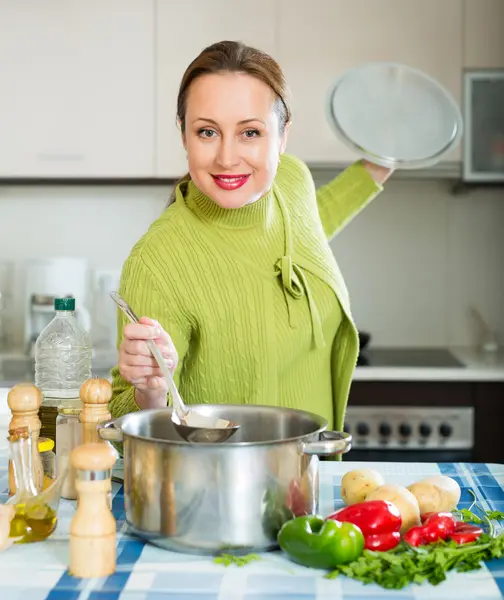 Жінка готує суп на кухні Стокове Фото