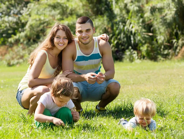 Familie van vier in zonnig park — Stockfoto