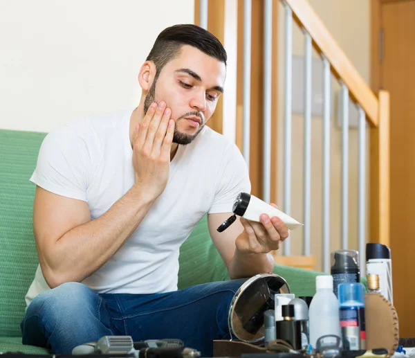 Mann trägt Gesichtscreme auf — Stockfoto