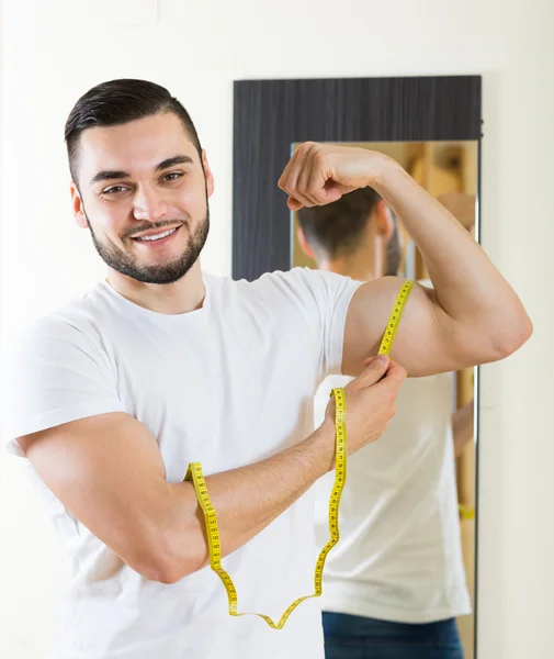 Uomo che misura il bicipite e il corpo — Foto Stock