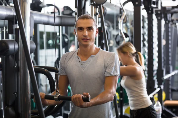 Podnoszenie ciężarów na maszyny w klubie fitness — Zdjęcie stockowe