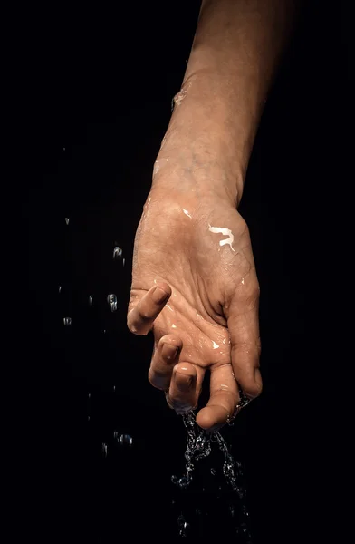 A wet hand on a black background — Stock Photo, Image