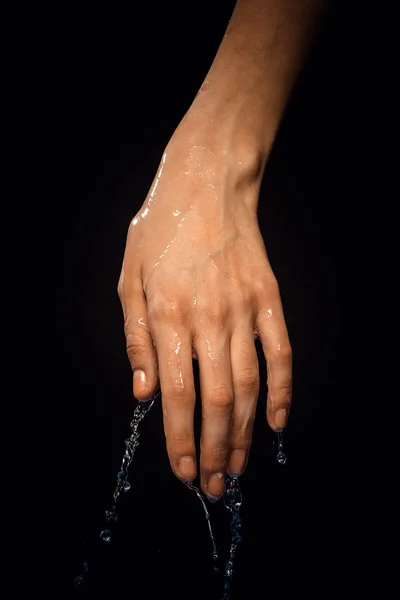 A wet hand on a black background — Stock Photo, Image