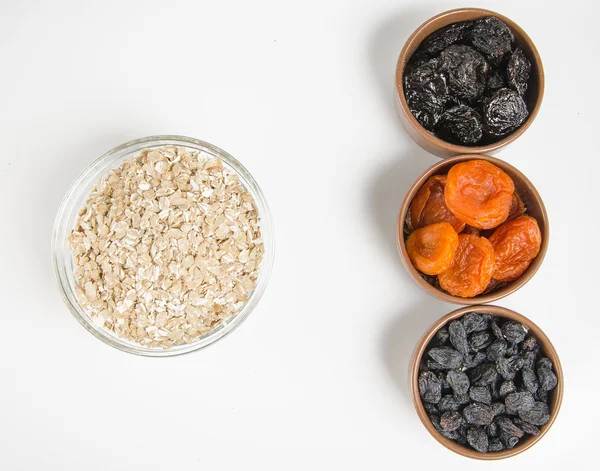 Oatmeal in a glass bowl and dried fruits — Stock Photo, Image