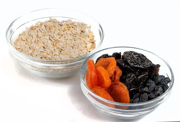 Oatmeal in a glass bowl and dried fruits — Stock Photo, Image