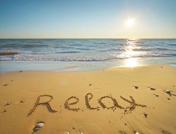 Słowo Relaks Odręcznie Napisane Piaszczystej Plaży Zachodzie Słońca Charakter Scena — Zdjęcie stockowe