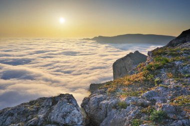 Bulutların üstünde gün batımı. Puslu doğa manzarası.