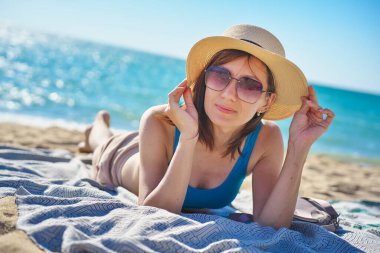 Tropikal Bach 'ta kumda dinlenen kadın portresi. Tatil, macera ya da tatil sahnesi.