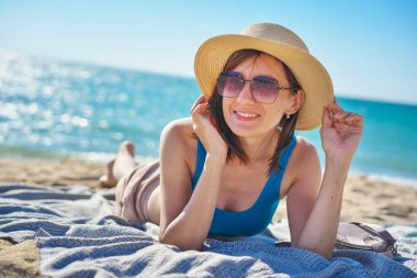 Tropikal Bach 'ta kumda dinlenen kadın portresi. Tatil, macera ya da tatil sahnesi.