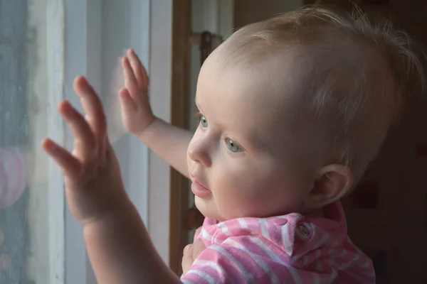 Schattige baby in de kamer staat in de buurt van venster — Stockfoto