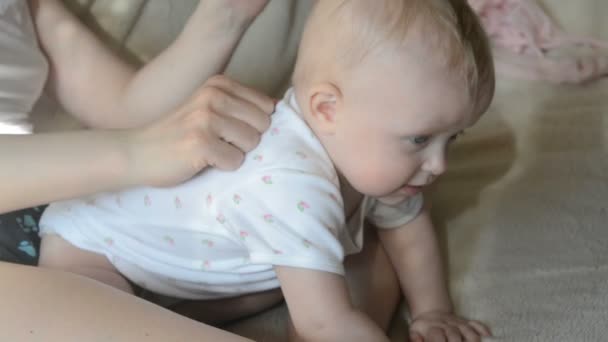 Moeder in masseren gelukkig zes maanden oude baby lichaam medische jurk — Stockvideo