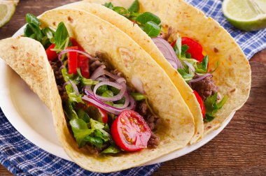 Ahşap masa üzerinde iki tacos