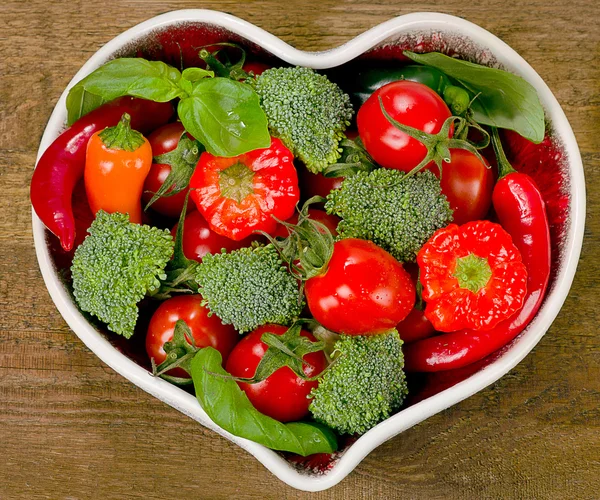 Fresh vegetables in heart shape plate — Stock Photo, Image