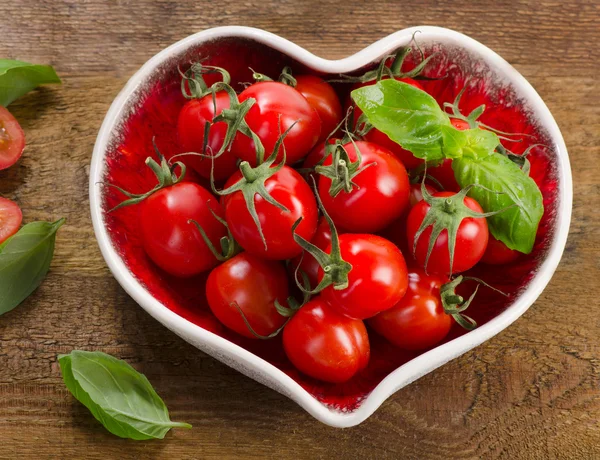 Tomaten im herzförmigen Teller — Stockfoto