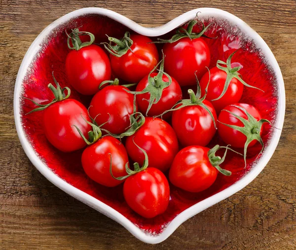 Tomaten im herzförmigen Teller — Stockfoto