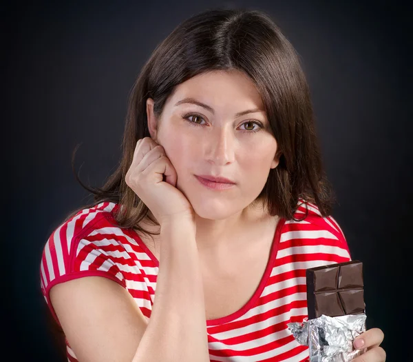Mulher comer barra de chocolate — Fotografia de Stock