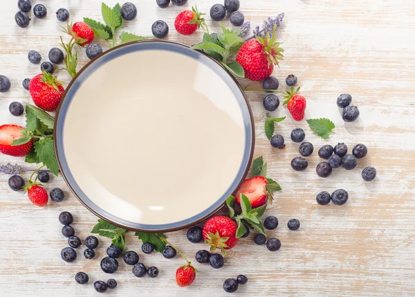 Fresh berries and plate — Stock Photo, Image