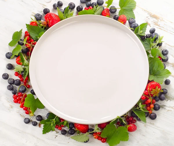 Fresh berries and plate — Stock Photo, Image