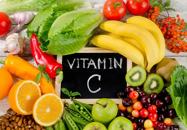 Alimentos ricos en vitamina C sobre tabla de madera. Alimentación saludable . — Foto de Stock