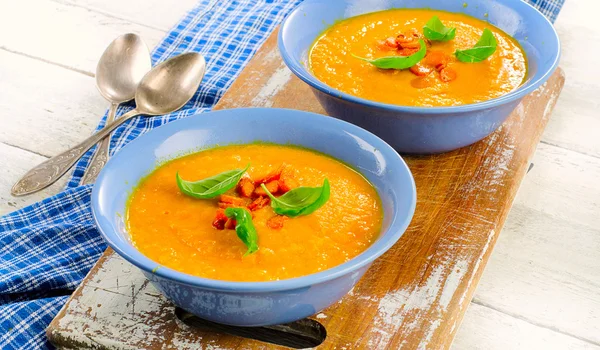 Морковный суп в синих тарелках — стоковое фото