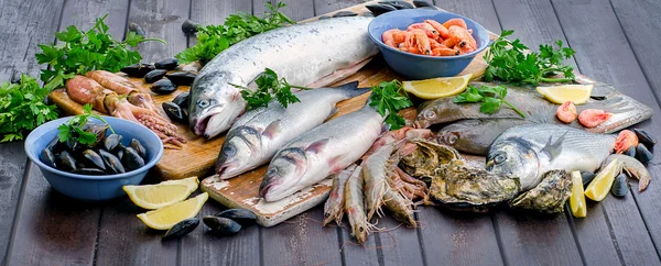 Ahşap bir masa üzerinde ham deniz ürünleri. — Stok fotoğraf