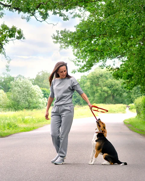 Młoda kobieta bawiąca się psem — Zdjęcie stockowe