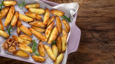 Ot ve sosla pişirilmiş köy usulü patates dilimleri. Üst görünüm, alanı kopyala