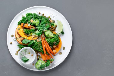 Kızarmış balkabağı salatası ve sebze. Sağlıklı vejetaryen yemeği. Üst görünüm, alanı kopyala