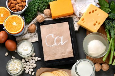 Sağlıklı günlük ve günlük olmayan ürünler koyu arka planda kalsiyum açısından zengin. Sağlıklı yiyecekler. Tebeşir tahtası, üst görünüm