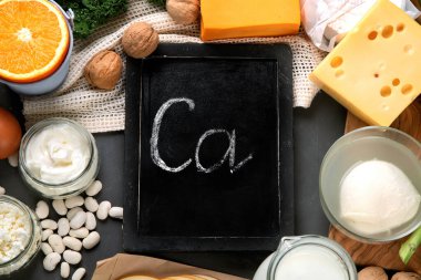 Sağlıklı günlük ve günlük olmayan ürünler koyu arka planda kalsiyum açısından zengin. Sağlıklı yiyecekler. Tebeşir tahtası, üst görünüm
