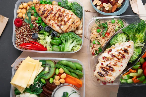 Healthy meal prep containers with chickpeas, chicken, tomatoes, cucumbers  and avocados. Healthy lunch in glass containers on beige rustic background.  Zero waste concept. Selective focus. Stock Photo