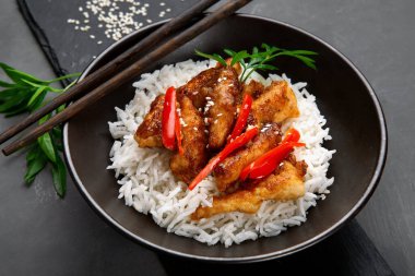 Soslu tavuk, pilav ve sebzeyle servis edilir.. 