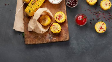 Gemide az pişmiş ve biberli mısır koçanları var. Kese kağıdında dilimlenmiş mısır. Kopyalama alanı olan üst görünüm