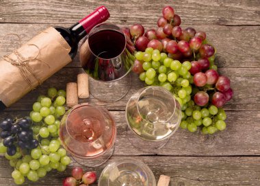 Şarap ve atıştırmalık seti çeşitleri. Farklı üzüm türleri. Ahşap arka planda taze malzemeler. Üst görünüm