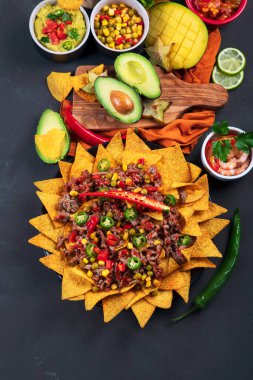 Lezzetli İspanyol Meksika yemeği tahtası. Nachos, taco, guacamole, karides, avokado ve yıldız meyvesi. Acı ve baharatlı. Üst görünüm, alanı kopyala