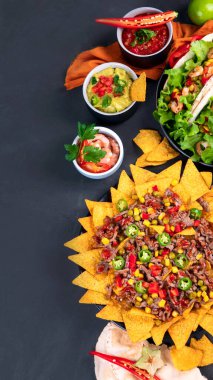 Lezzetli İspanyol Meksika yemeği tahtası. Nachos, taco, guacamole, karides, avokado ve yıldız meyvesi. Acı ve baharatlı. Üst görünüm, alanı kopyala