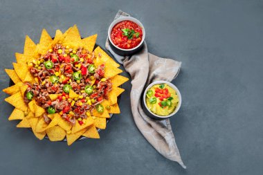 Lezzetli İspanyol Meksika yemeği tahtası. Nacho, sığır eti, guacamole, avokado ve yıldız meyvesi. Acı ve baharatlı. Üst görünüm, alanı kopyala