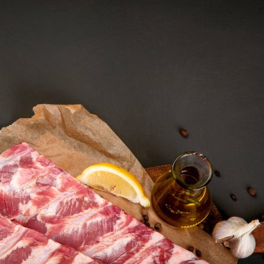 Koyu arkaplanda baharatla tatlandırılmış taze çiğ domuz pirzolası. Üst görünüm, Spac kopyala