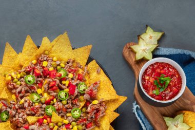 Lezzetli İspanyol Meksika yemeği tahtası. Nacho, sığır eti, guacamole, avokado ve yıldız meyvesi. Acı ve baharatlı. Üst görünüm, alanı kopyala