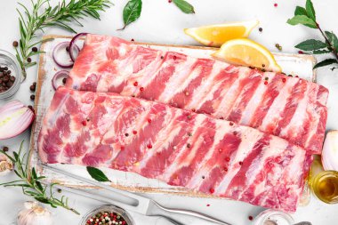 Açık gri arka planda baharatlı taze çiğ domuz pirzolası. Üst yaşam