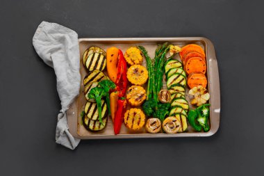 Siyah arka planda bej tepside ızgara sebzeler. Izgara menüsü. Üst görünüm