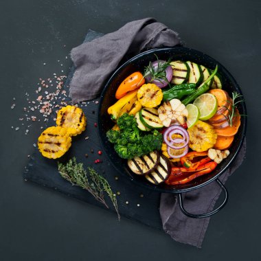 Izgara sebzeler, siyah arka planda dökme demir tavada. Izgara menüsü. Üst görünüm, alanı kopyala