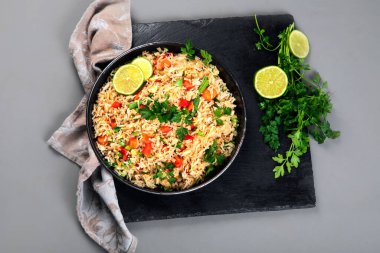 Yumurtalı bir tabak kızarmış pirinç, biber, havuç, yeşil fasulye ve biraz yeşillik gibi sebzeler. Gri arka plan. Üst yaşam