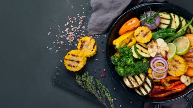 Izgara sebzeler, siyah arka planda dökme demir tavada. Izgara menüsü. Üst görünüm, alanı kopyala