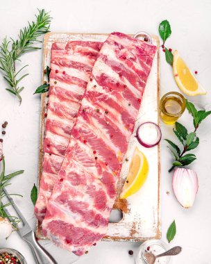 Açık gri arka planda baharatlı taze çiğ domuz pirzolası. Üst görünüm