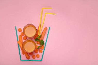 Renkli arka planda havuç suyundan yapılmış bir bardak. Minimalizm tasarım konsepti. Üst görünüm, Spac kopyala